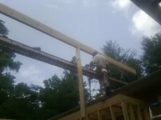 Carpenter setting a ridge beam over a new addition frame — Ice Dam Removal by Roofing Brothers in Ocean Grove