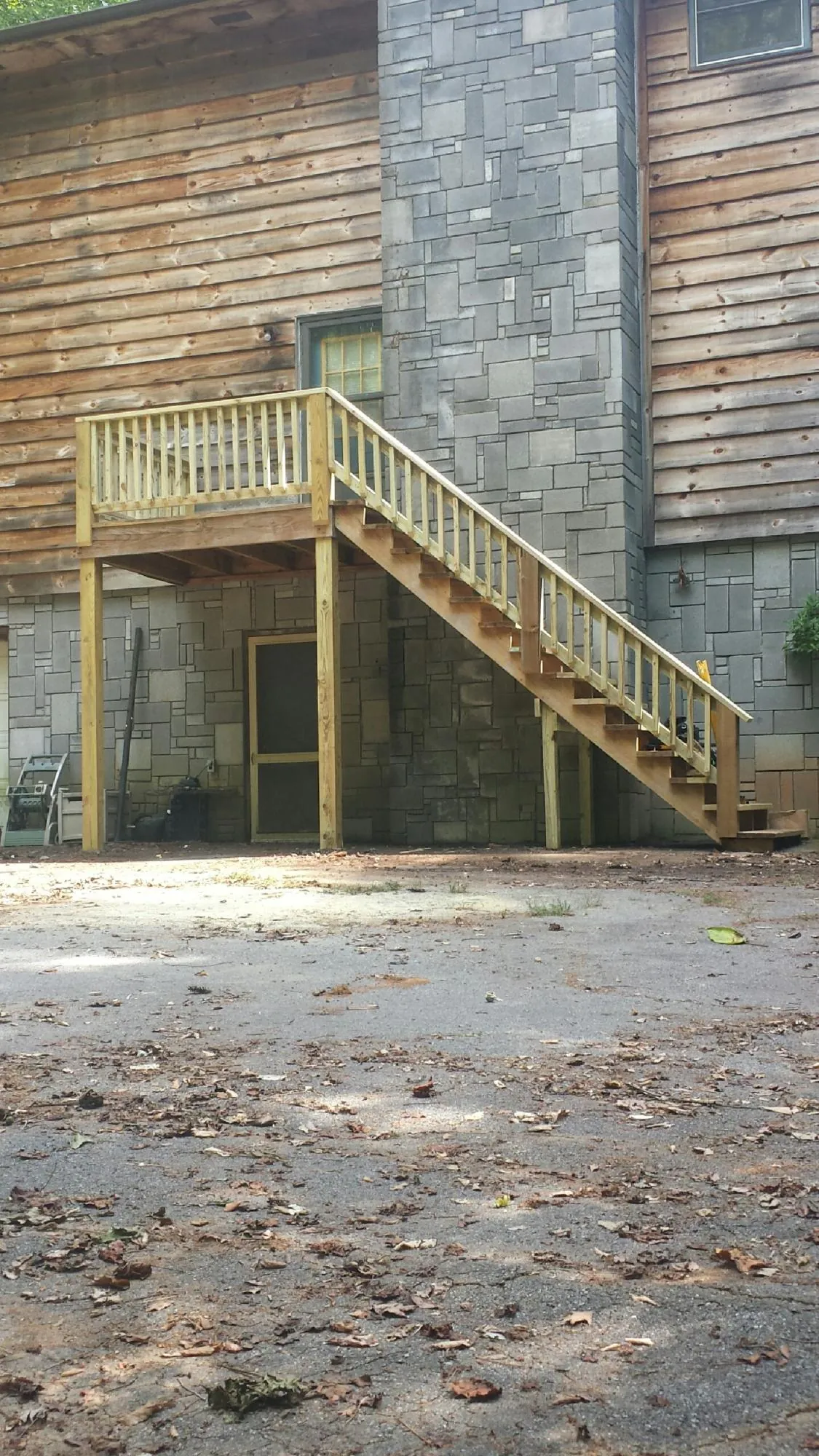 New pressure treated deck and stair landing on a log home in Ocean Grove