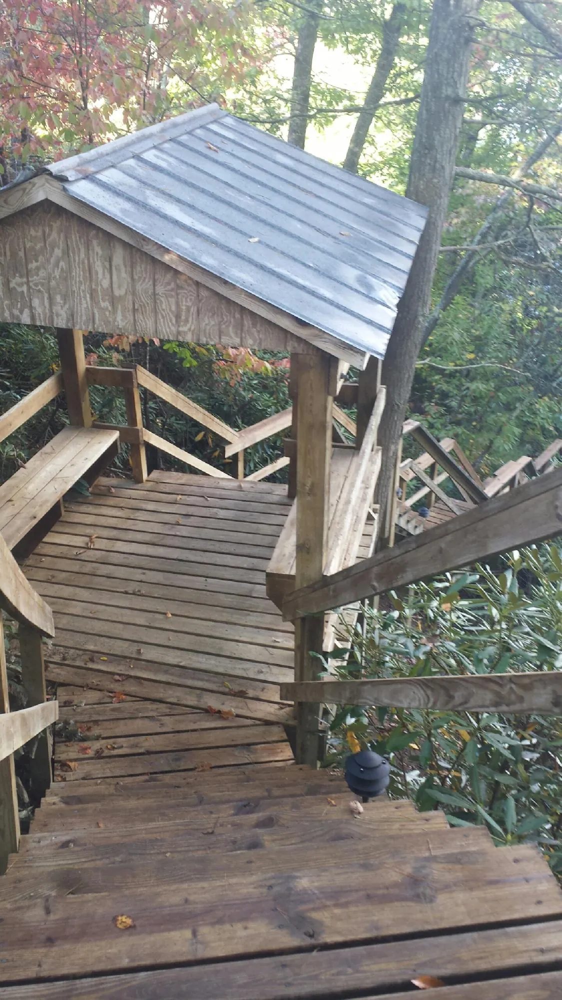 Metal roofed shelter over wooden steps on a wooded walkway — Skylight Repair & Installation work by our crew in Ocean Grove